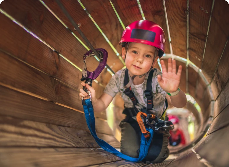 Child climbing through wooden tunnel