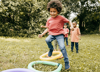 Young boy jumping through colorful rings