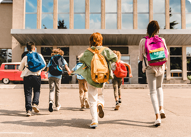 Children running towards school building