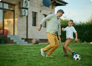 Family playing soccer in backyard