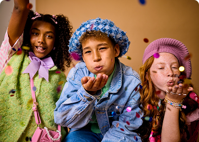 Kids blowing confetti at party