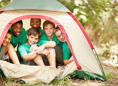 Kids smiling inside a camping tent